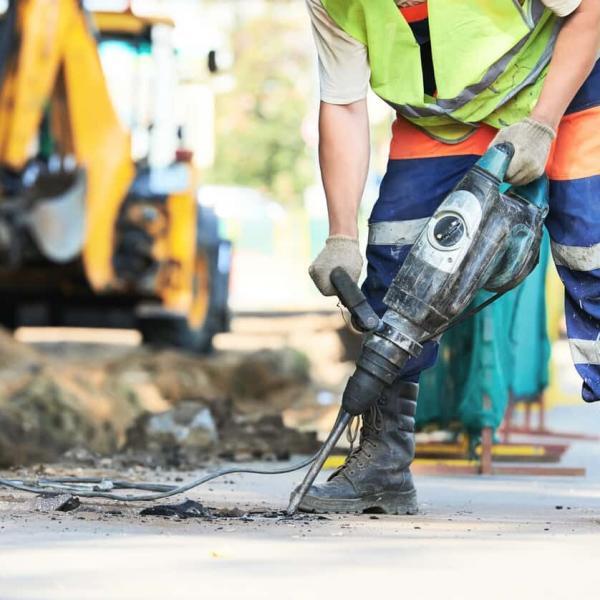 Road construction worker with perforator