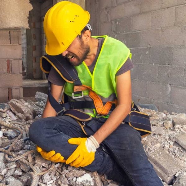 injured construction worker holding his knee