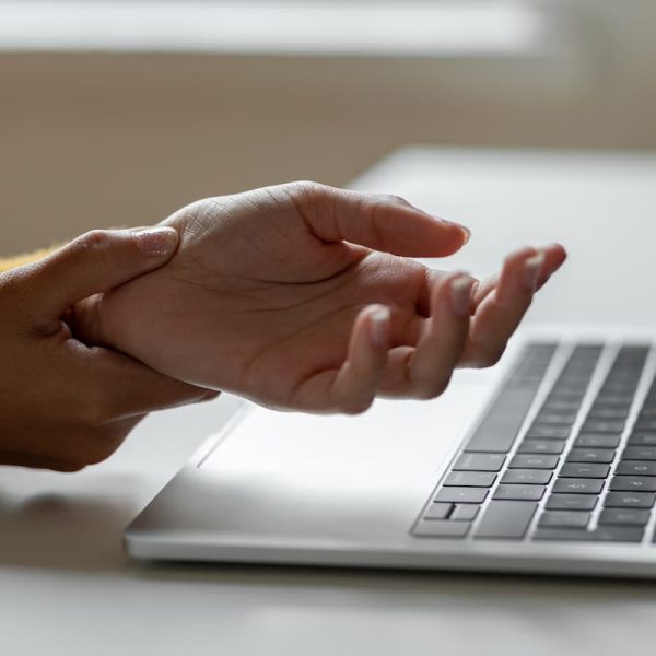 a woman holds her wrist after an injury from typing